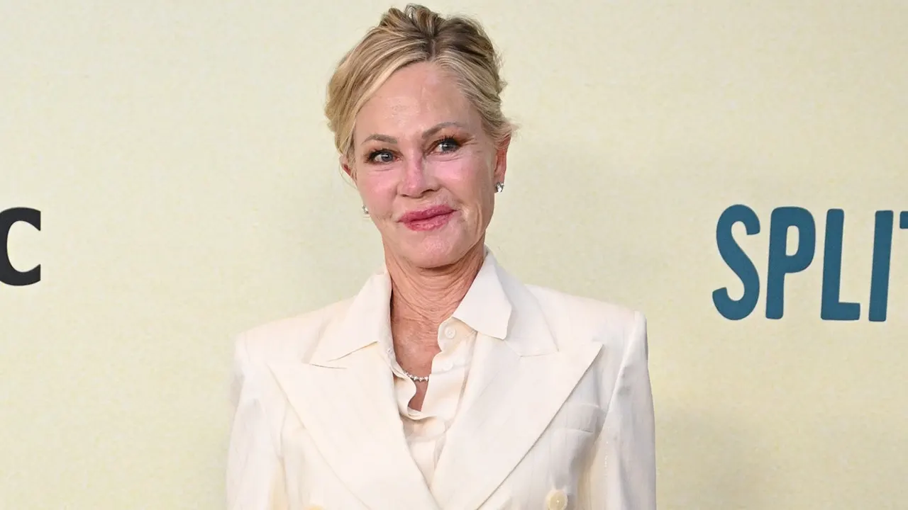 Melanie Griffith im schwarzen Badeanzug auf einem Steg am See